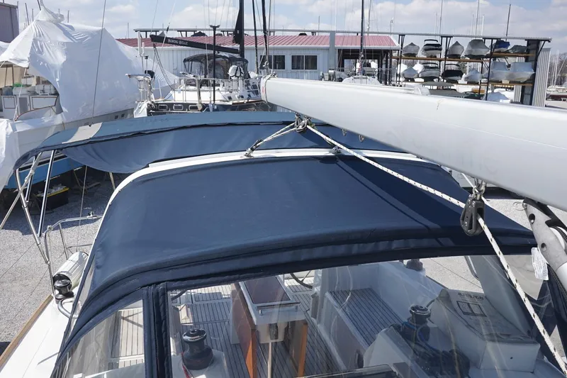 Slide: The Image of Beneteau Oceanis 38.1 sailboat, 2021 model, docked with blue canopy and visible mast. - 28