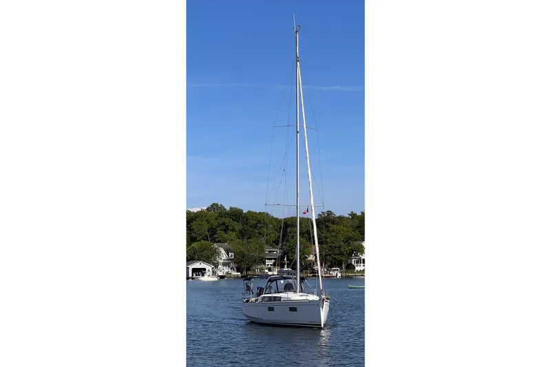 Slide: The Image of Beneteau Oceanis 38.1 sailboat, 2021 model, on a serene lake with clear blue sky. - 3