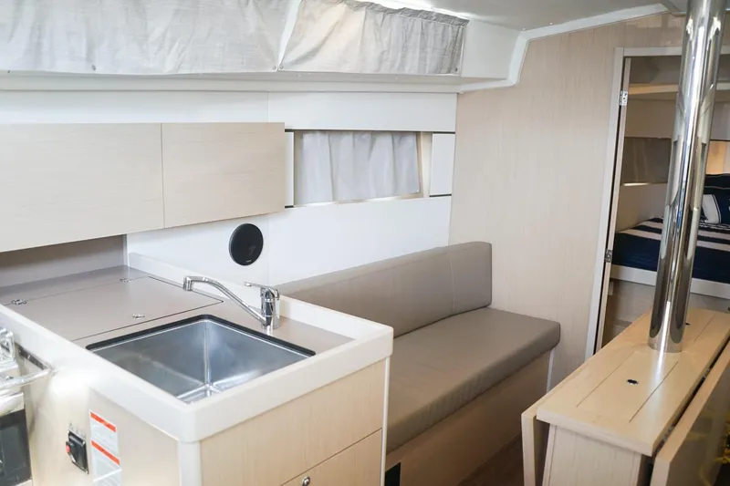 Slide: The Image of Interior of 2021 Beneteau Oceanis 38.1 yacht, featuring modern kitchen and seating area. - 31