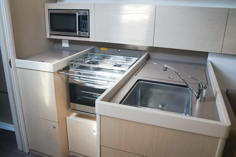 Slide: The Image of Modern kitchen in 2021 Beneteau Oceanis 38.1 yacht with sink, stove, and microwave. - 36