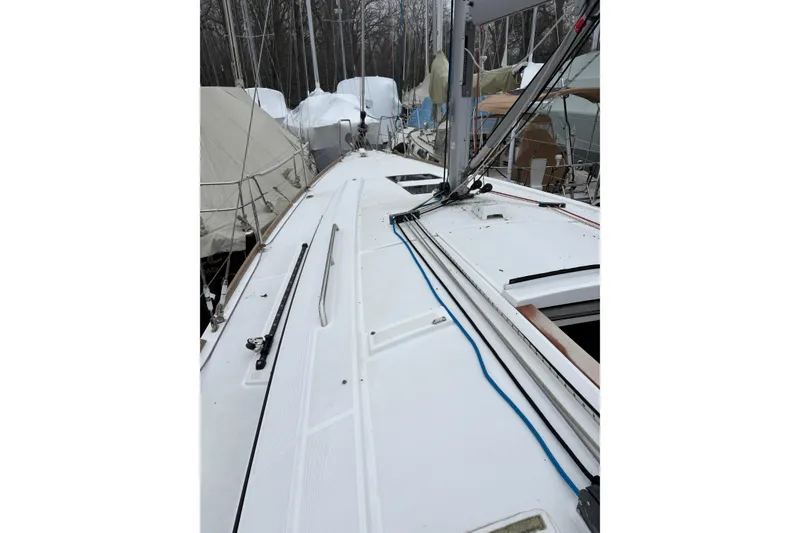 Slide: The Image of 2021 Beneteau Oceanis 38.1 sailboat deck with rigging and covered boats in background. - 8