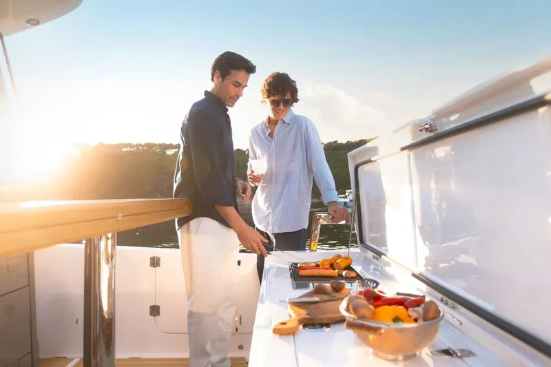 Slide: The Image of Couple enjoying outdoor cooking on Aiata Wayfinder 38 yacht, 2026 model, at sunset. - 13