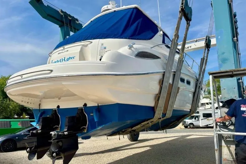 Slide: The Image of 2001 Sealine S41 Sports Cruiser being lifted by a crane at a marina. - 11