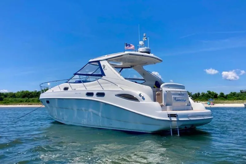 Slide: The Image of 2001 Sealine S41 Sports Cruiser on water, clear sky, and scenic shoreline. - 2