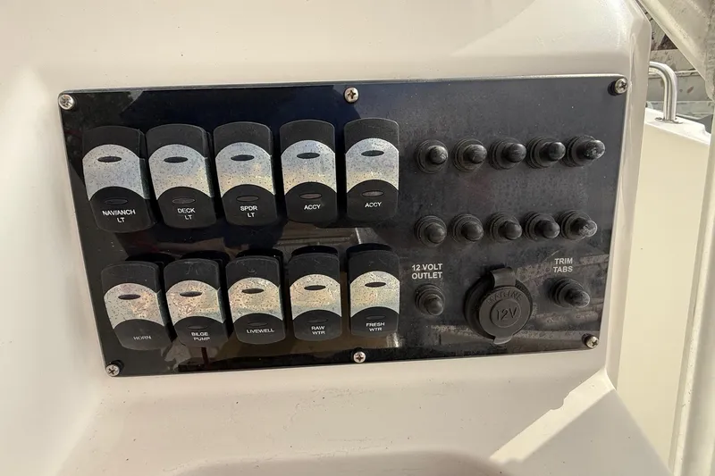 Slide: The Image of Control panel of a 2020 Edgewater 208CC boat with labeled switches and outlets. - 14