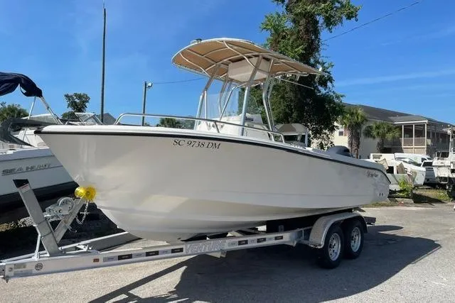 Slide: The Image of 2020 Edgewater 208CC boat on trailer, parked outdoors under clear blue sky. - 2