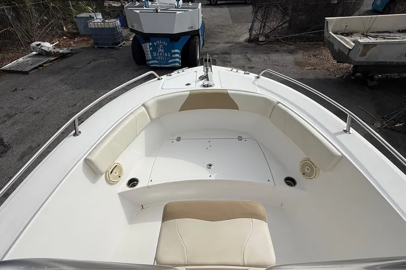 Slide: The Image of Bow seating area of a 2020 Edgewater 208CC boat, featuring cushioned seats and storage. - 23