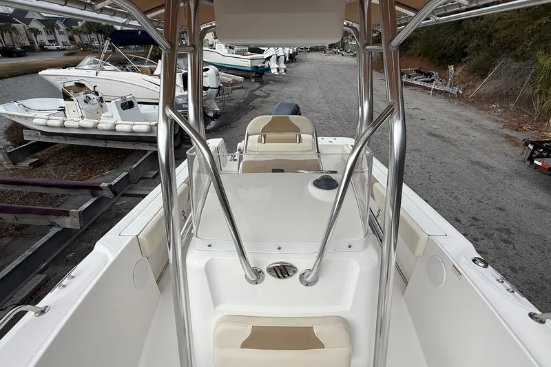 Slide: The Image of 2020 Edgewater 208CC boat interior with seating and metal framework, docked near other boats. - 29