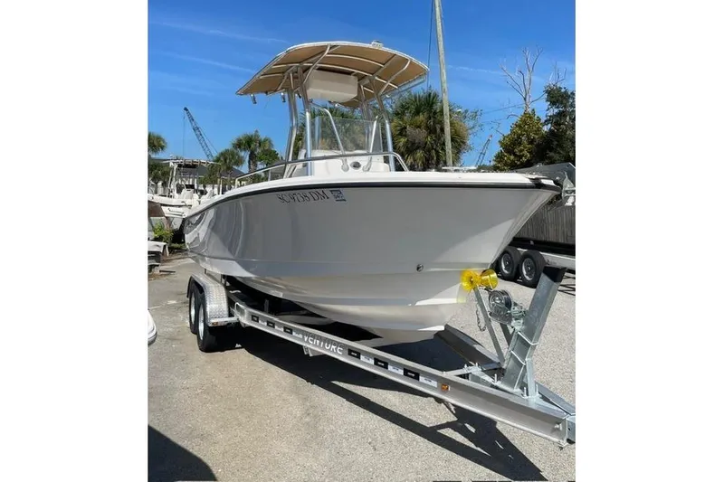 Slide: The Image of 2020 Edgewater 208CC boat on trailer, parked outdoors under clear blue sky. - 3