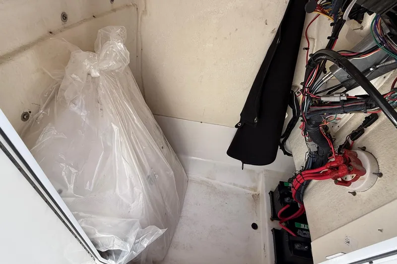 Slide: The Image of 2020 Edgewater 208CC boat interior wiring and storage compartment view. - 32