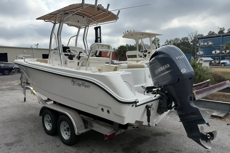 Slide: The Image of 2020 Edgewater 208CC boat with Yamaha 150 engine on a trailer, parked outdoors. - 4