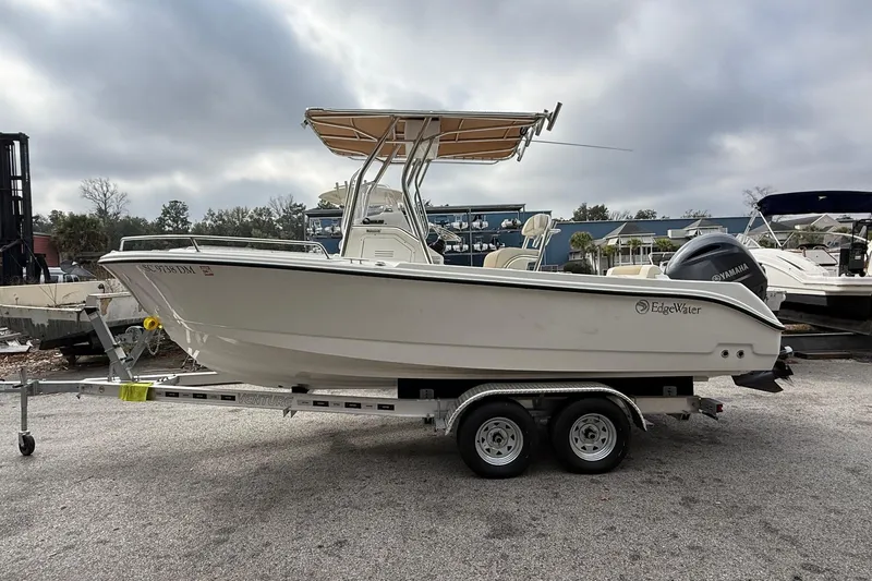 Slide: The Image of 2020 Edgewater 208CC boat on trailer, parked outdoors under cloudy sky. - 5