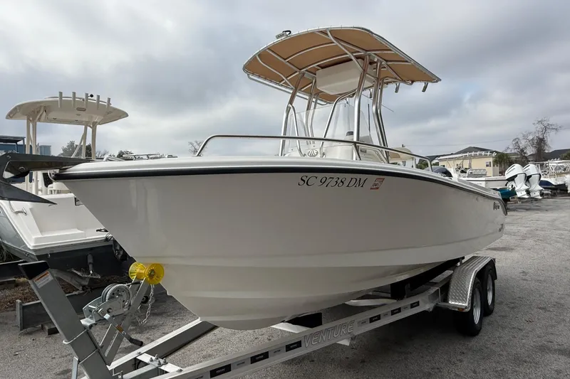 Slide: The Image of 2020 Edgewater 208CC boat on trailer, parked outdoors under cloudy sky. - 6