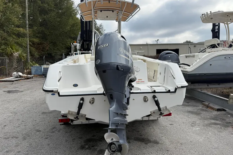 Slide: The Image of 2020 Edgewater 208CC boat with Yamaha 150 outboard motor, parked outdoors. - 8