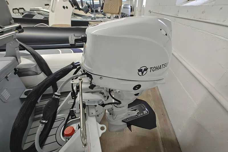 Slide: The Image of 2021 Highfield Classic 310 FCT with Tohatsu outboard motor in a showroom. - 4