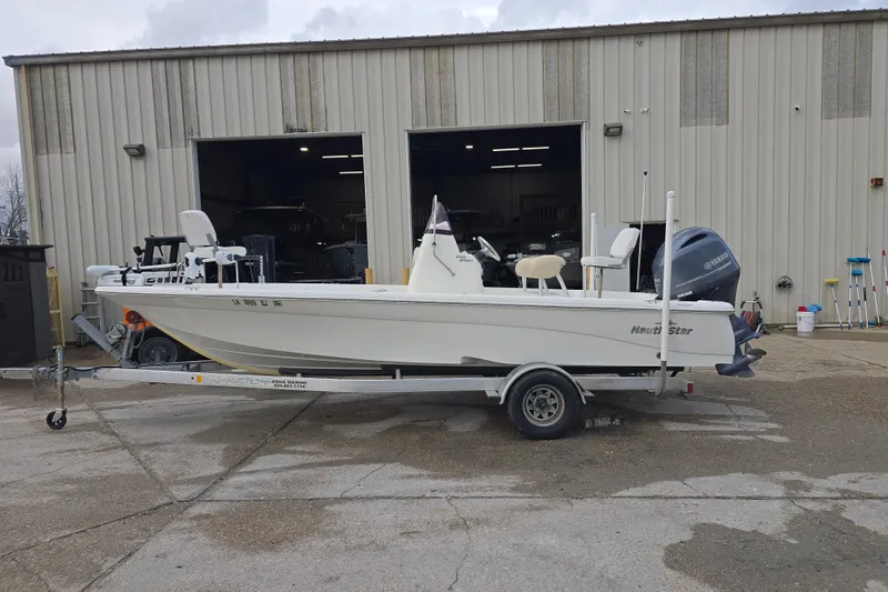 Slide: The Image of 2018 NauticStar 2140 Sport boat on trailer outside a warehouse. - 2