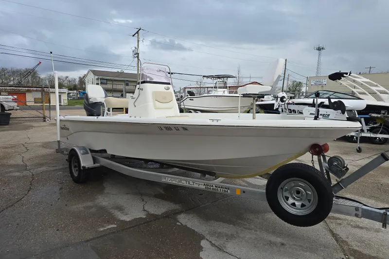 Slide: The Image of 2018 NauticStar 2140 Sport boat on trailer, parked outdoors under cloudy sky. - 5