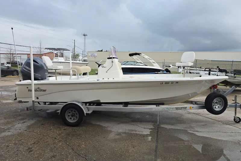 Slide: The Image of 2018 NauticStar 2140 Sport boat on trailer, parked outdoors under cloudy sky. - 6