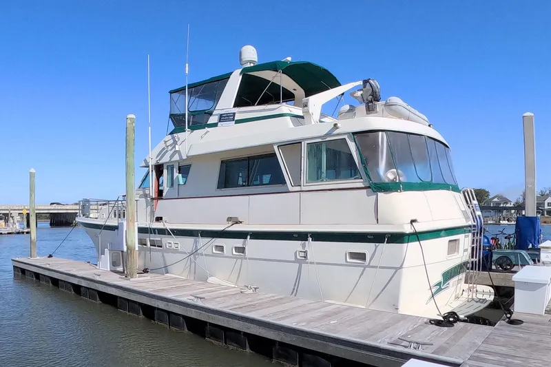 The Image of 1987 Hatteras 54 Motor Yacht docked at marina under clear blue sky. - 0