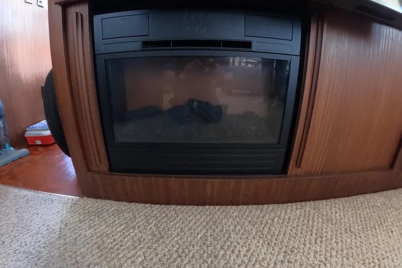Slide: The Image of Fireplace inside 1987 Hatteras 54 Motor Yacht, surrounded by wooden paneling. - 11