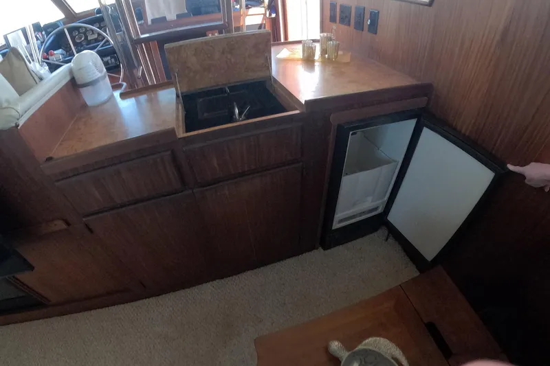 Slide: The Image of 1987 Hatteras 54 Motor Yacht interior with sink, mini fridge, and wooden cabinetry. - 12