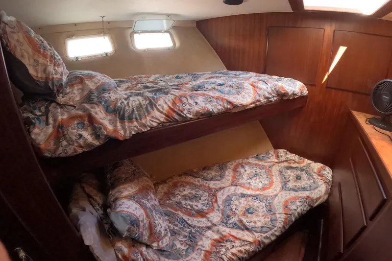 Slide: The Image of 1987 Hatteras 54 Motor Yacht cabin with bunk beds and patterned bedding. - 15