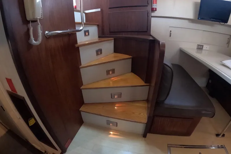 Slide: The Image of Interior of 1987 Hatteras 54 Motor Yacht with wooden stairs and seating area. - 19
