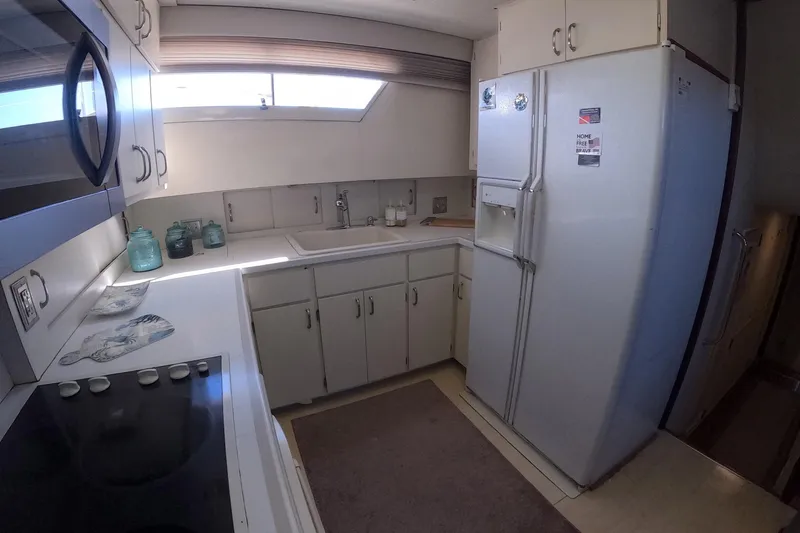 Slide: The Image of 1987 Hatteras 54 Motor Yacht kitchen with white cabinets and appliances. - 20