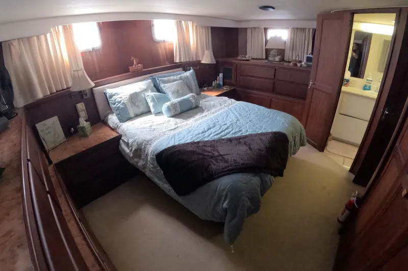 Slide: The Image of Luxurious bedroom interior of 1987 Hatteras 54 Motor Yacht with cozy bedding and wooden accents. - 26