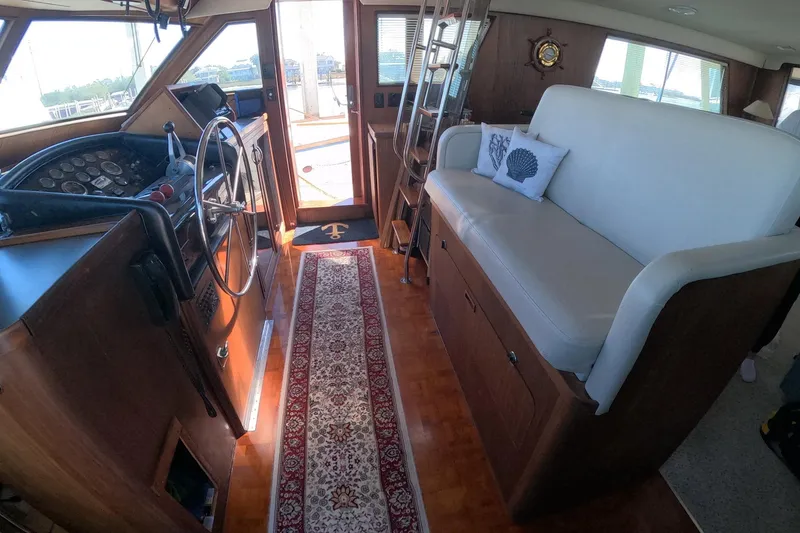 Slide: The Image of 1987 Hatteras 54 Motor Yacht interior with helm, seating, and nautical decor. - 3