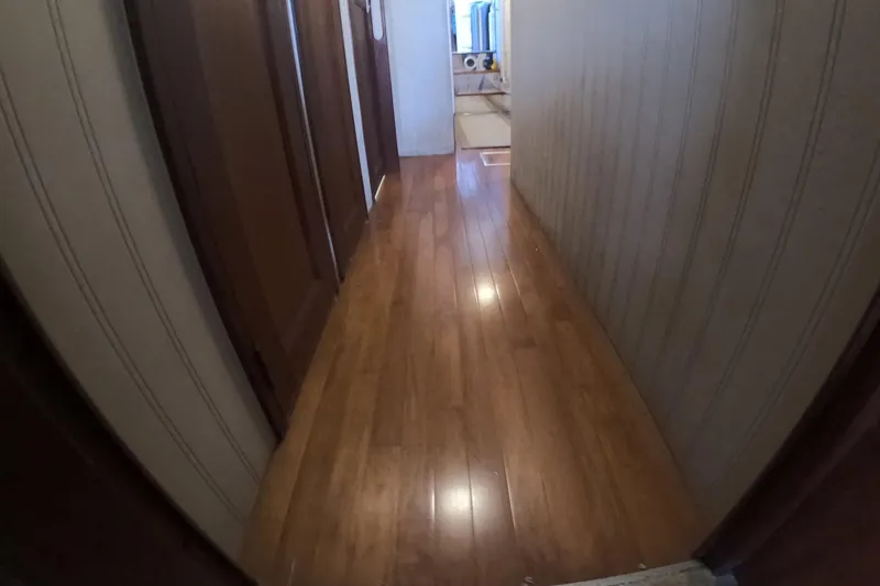 Slide: The Image of Hallway with wooden flooring inside a 1987 Hatteras 54 Motor Yacht. - 31
