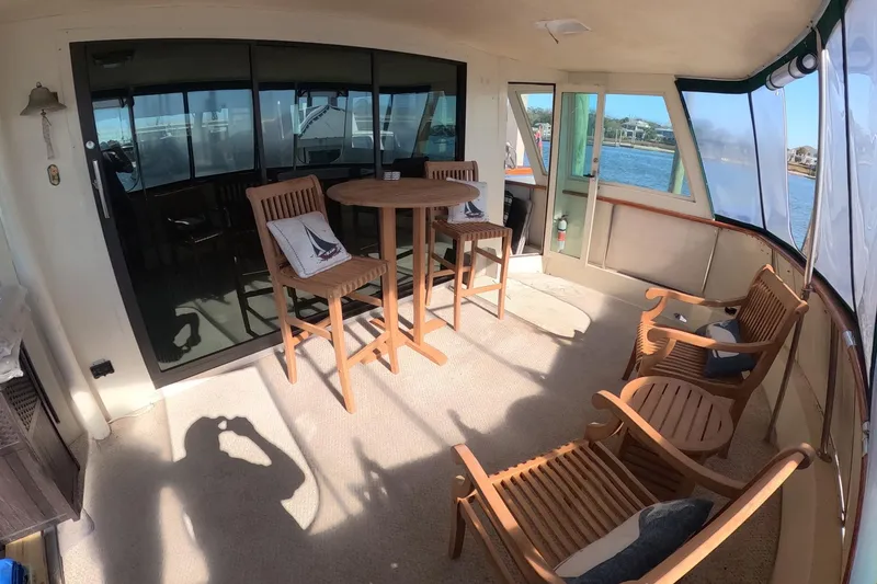 Slide: The Image of 1987 Hatteras 54 Motor Yacht interior with wooden furniture and scenic water view. - 32