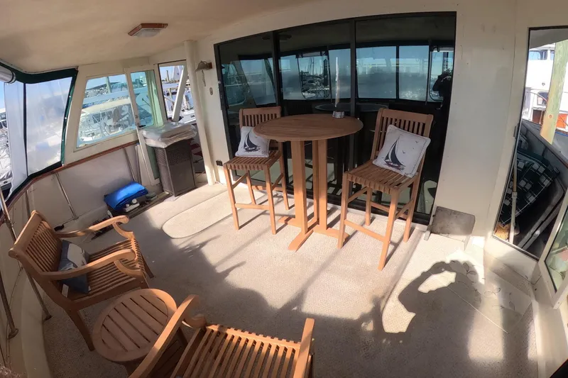 Slide: The Image of 1987 Hatteras 54 Motor Yacht interior with wooden chairs and table on deck. - 33