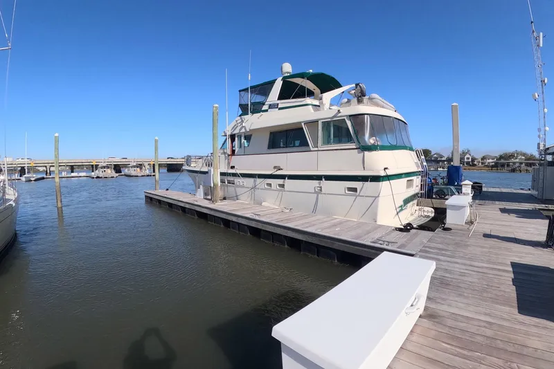 Slide: The Image of 1987 Hatteras 54 Motor Yacht docked at marina under clear blue sky. - 37