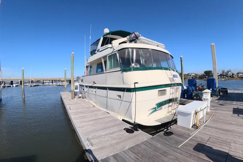 Slide: The Image of 1987 Hatteras 54 Motor Yacht docked at marina under clear blue sky. - 38