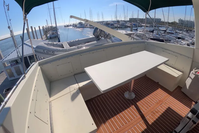 Slide: The Image of 1987 Hatteras 54 Motor Yacht deck with table, marina view, and docked boats. - 42