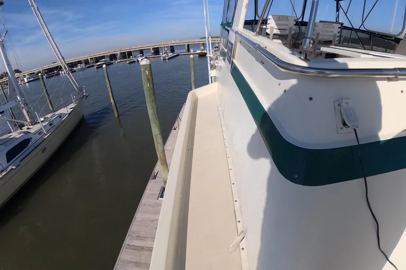 Slide: The Image of 1987 Hatteras 54 Motor Yacht docked at marina, clear sky, calm water. - 46