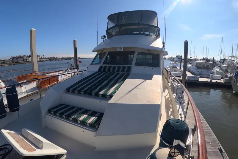 Slide: The Image of 1987 Hatteras 54 Motor Yacht docked at marina under clear blue sky. - 47