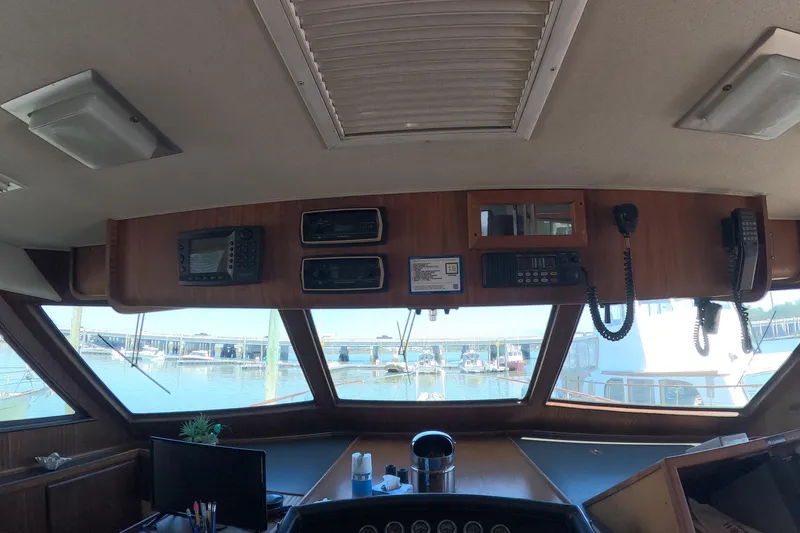 Slide: The Image of 1987 Hatteras 54 Motor Yacht helm with navigation equipment and marina view. - 56