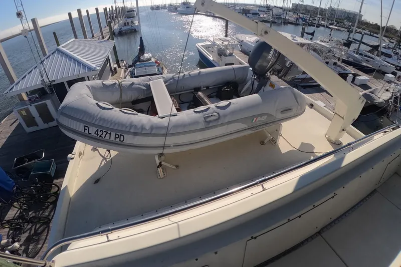 Slide: The Image of 1987 Hatteras 54 Motor Yacht with inflatable dinghy on deck at marina. - 64