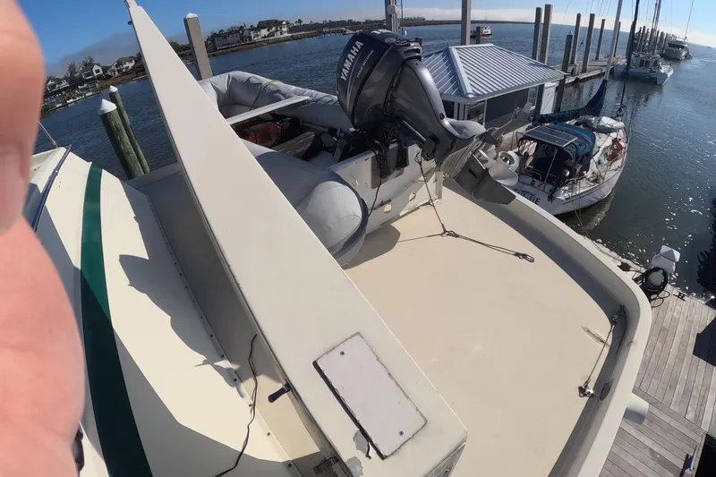 Slide: The Image of 1987 Hatteras 54 Motor Yacht docked with Yamaha outboard motor on deck. - 65
