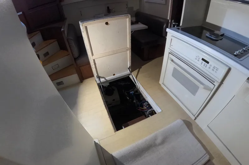 Slide: The Image of 1987 Hatteras 54 Motor Yacht interior with open engine access panel in kitchen area. - 66