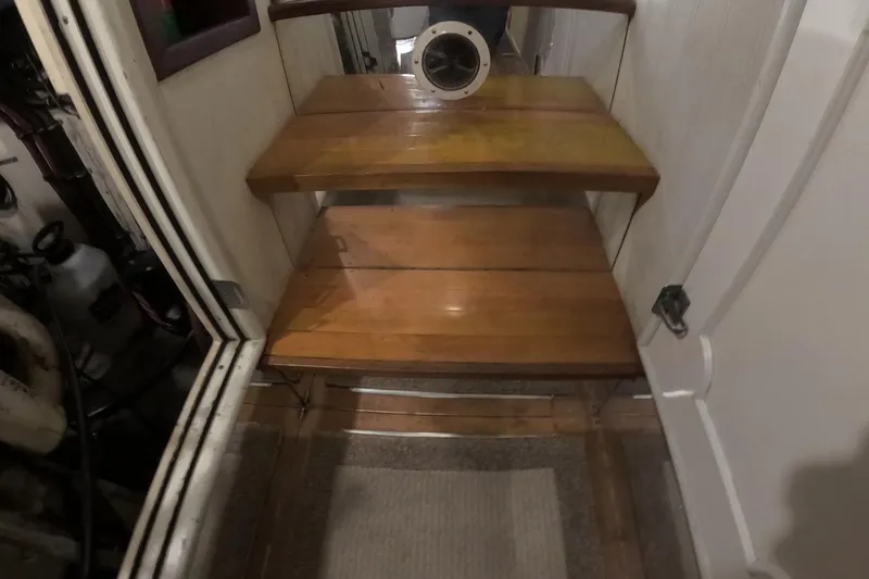 Slide: The Image of Wooden stairs inside a 1987 Hatteras 54 Motor Yacht, featuring a circular mirror. - 68