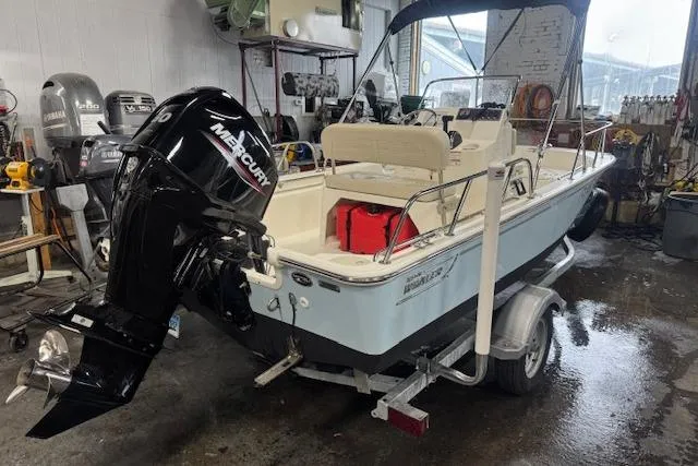 Slide: The Image of 2024 Boston Whaler 150 Montauk boat in garage, featuring Mercury outboard motor. - 11