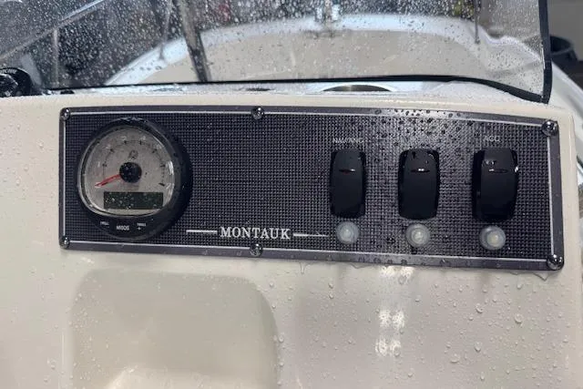 Slide: The Image of Control panel of 2024 Boston Whaler 150 Montauk boat, featuring gauges and switches. - 12