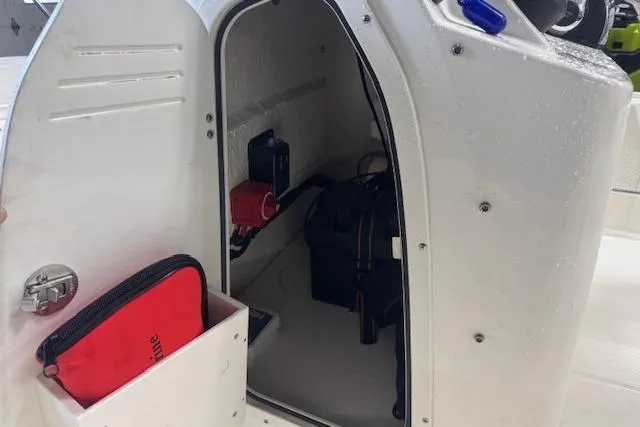 Slide: The Image of 2024 Boston Whaler 150 Montauk storage compartment with safety equipment and gear. - 13