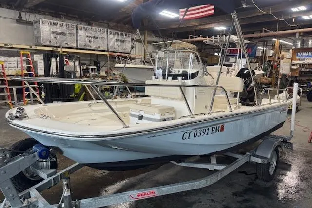 Slide: The Image of 2024 Boston Whaler 150 Montauk boat on trailer in a workshop setting. - 3