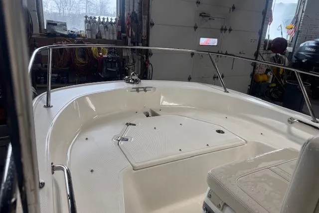 Slide: The Image of 2024 Boston Whaler 150 Montauk boat interior in a garage setting. - 4