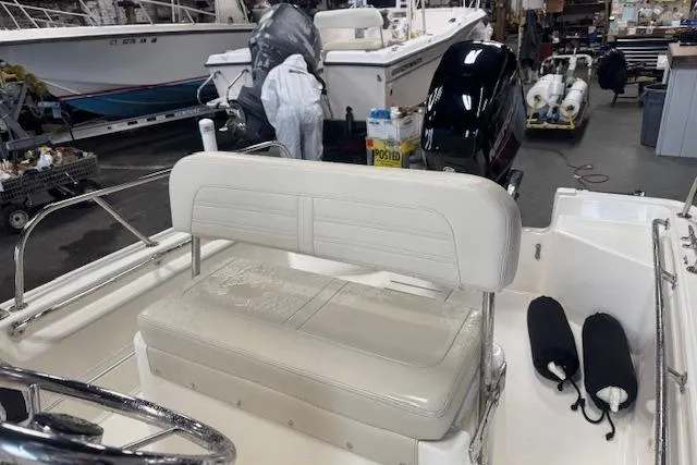 Slide: The Image of 2024 Boston Whaler 150 Montauk boat interior with seating and equipment in a workshop. - 6