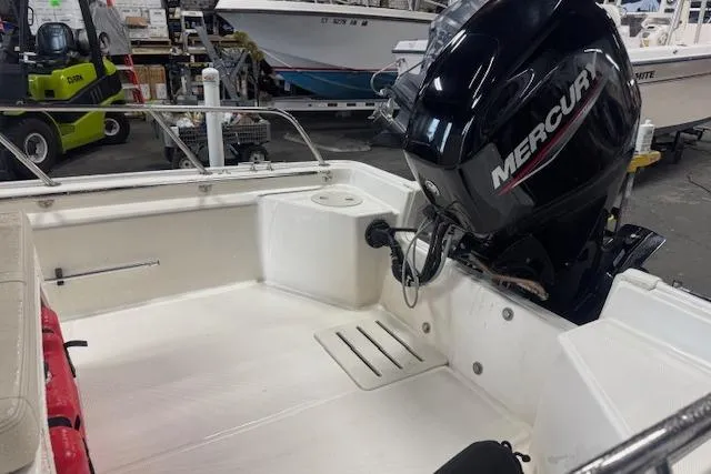 Slide: The Image of 2024 Boston Whaler 150 Montauk boat with Mercury engine in a showroom. - 8